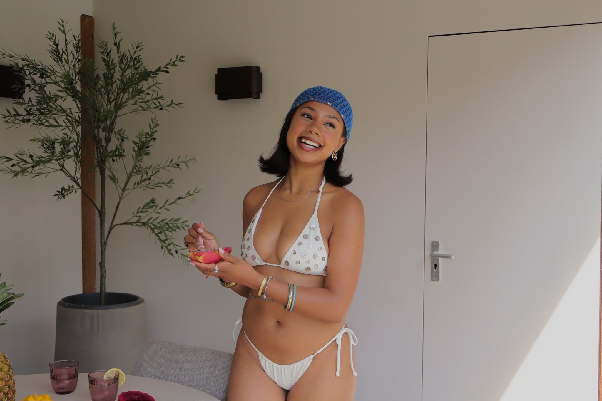 Bella Pearl bikini lifestyle - laughing with dragon fruit indoors